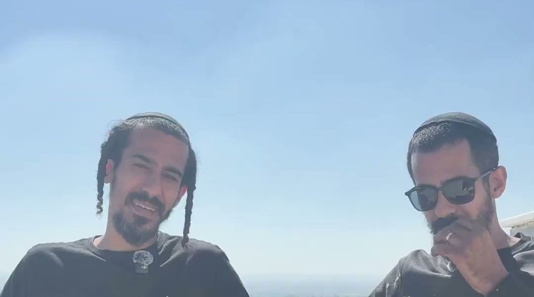 שני בעלי העסק עומדים על גג בניין, קו רקיע של עיר מאחוריהם